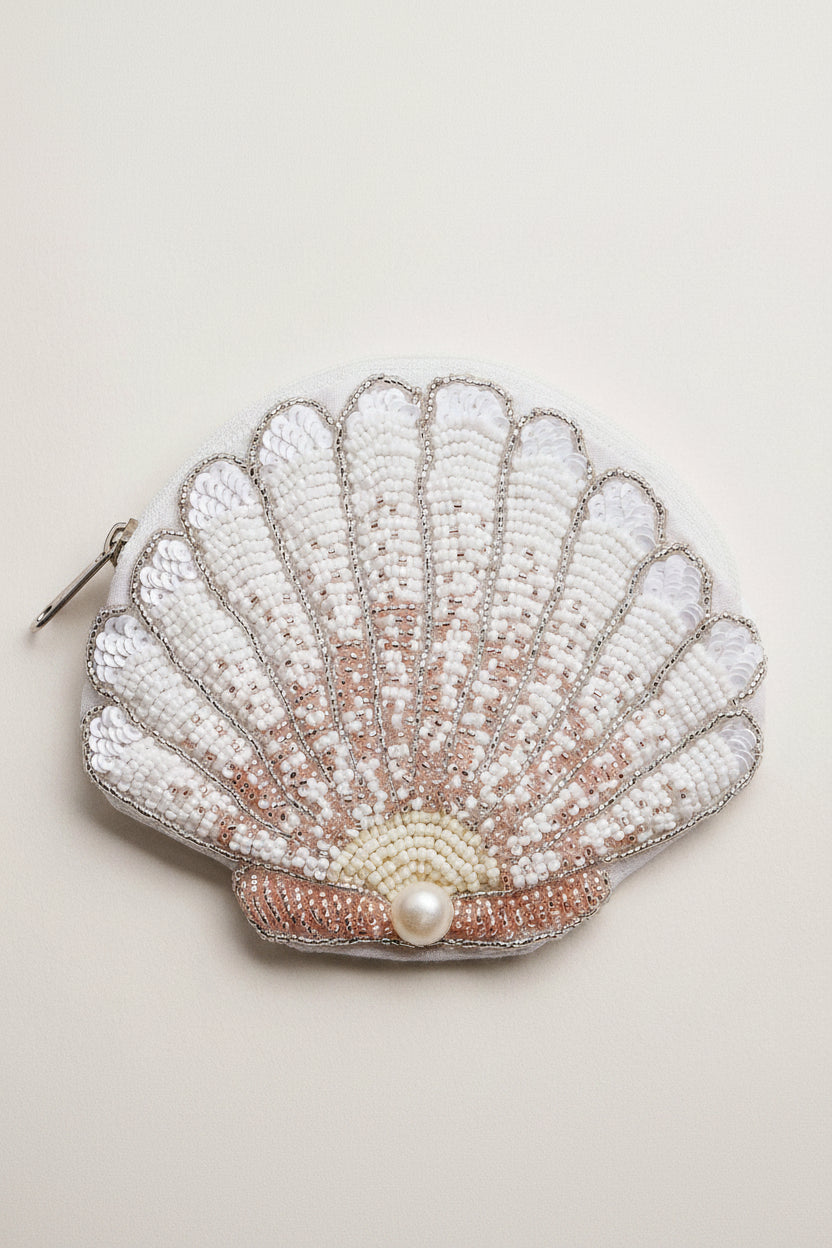 Shell-shaped pouch with beading and a pearl on a light background