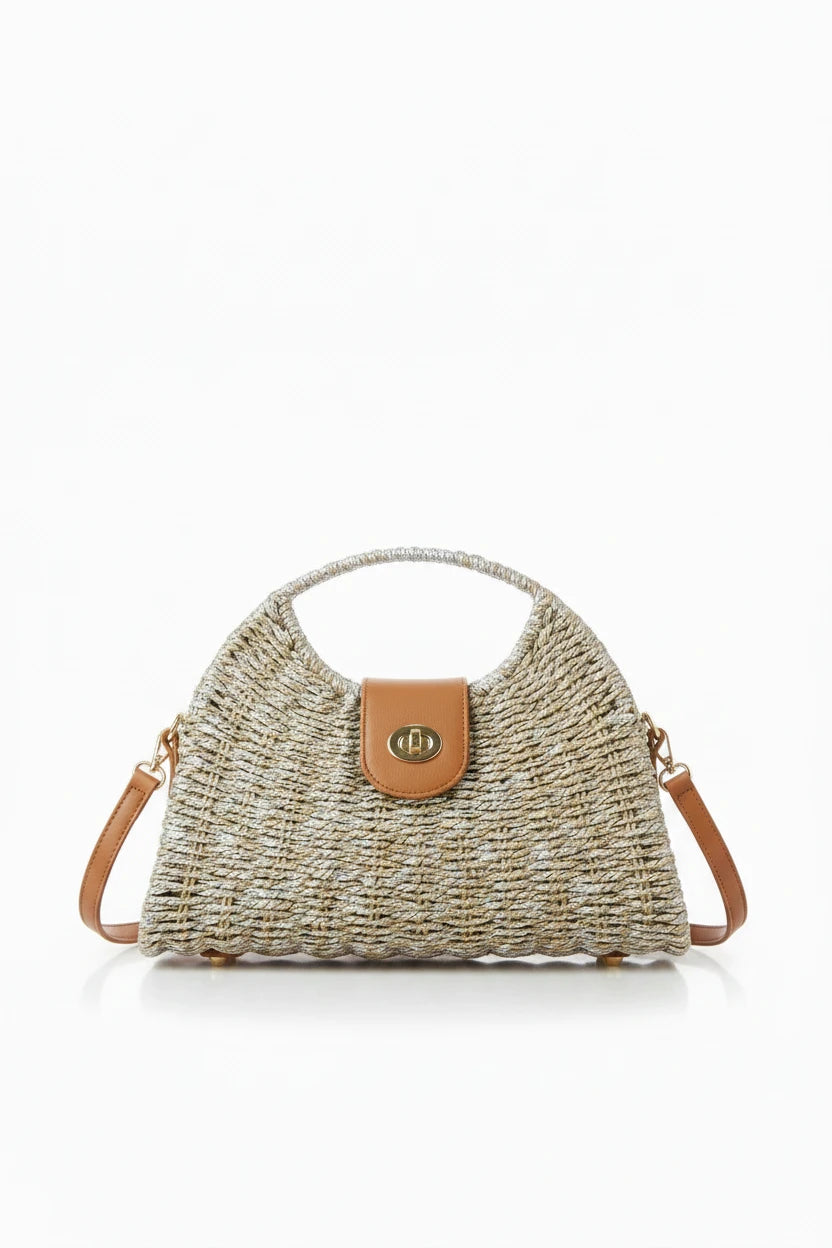 Woven handbag with a brown leather patch on a wooden surface