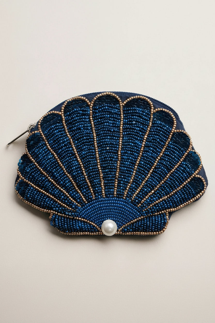 Blue beaded shell-shaped purse with a pearl on a light gray background