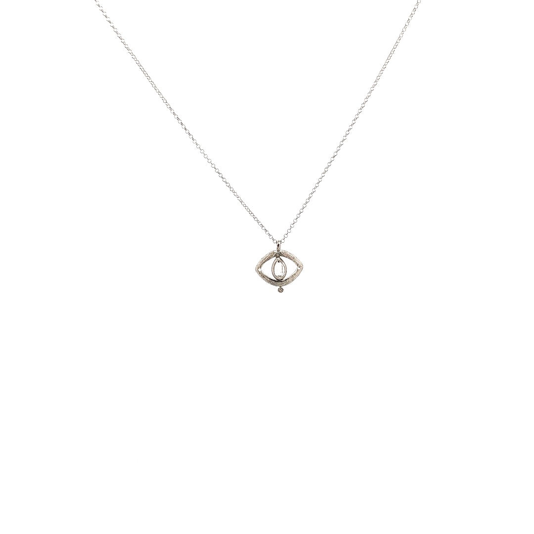A silver necklace with a central rough diamond and a design resembling an evil eye, intended for protection.