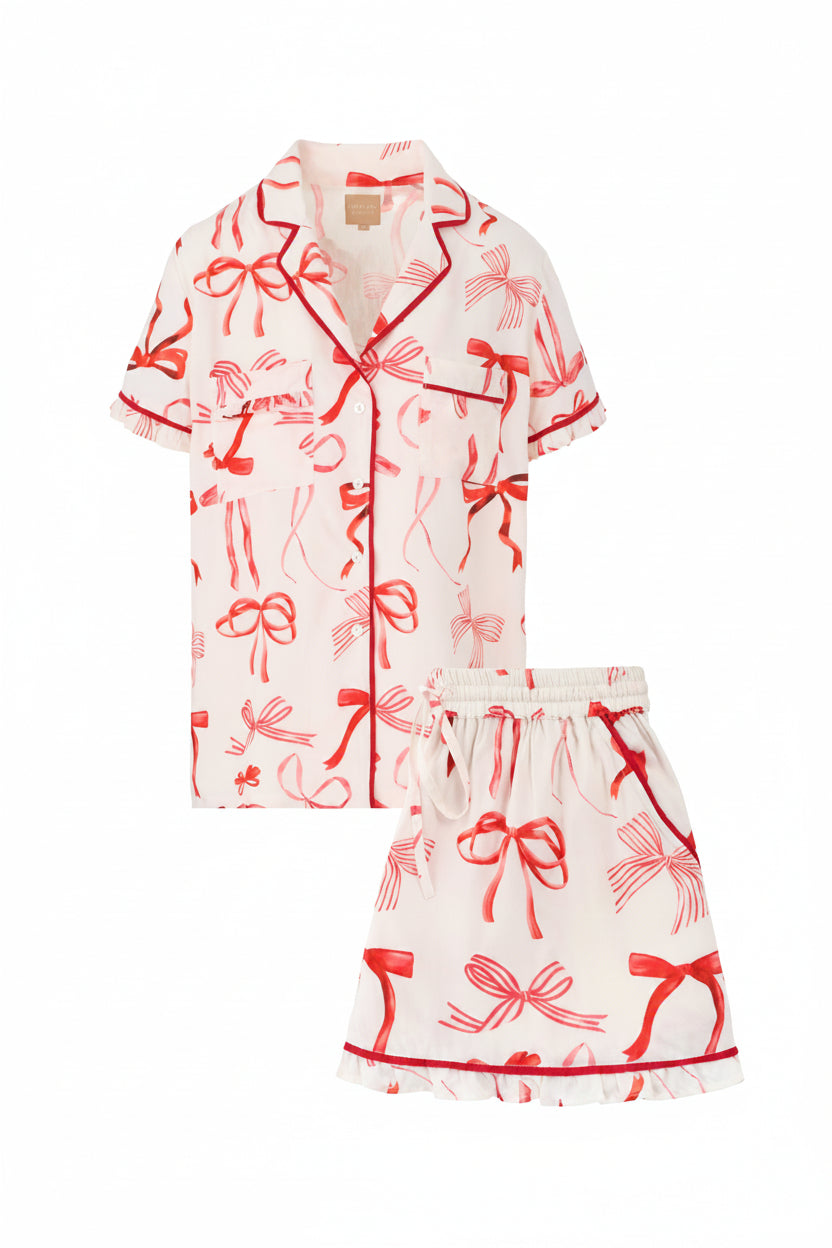 White outfit with red bow pattern on a white background
