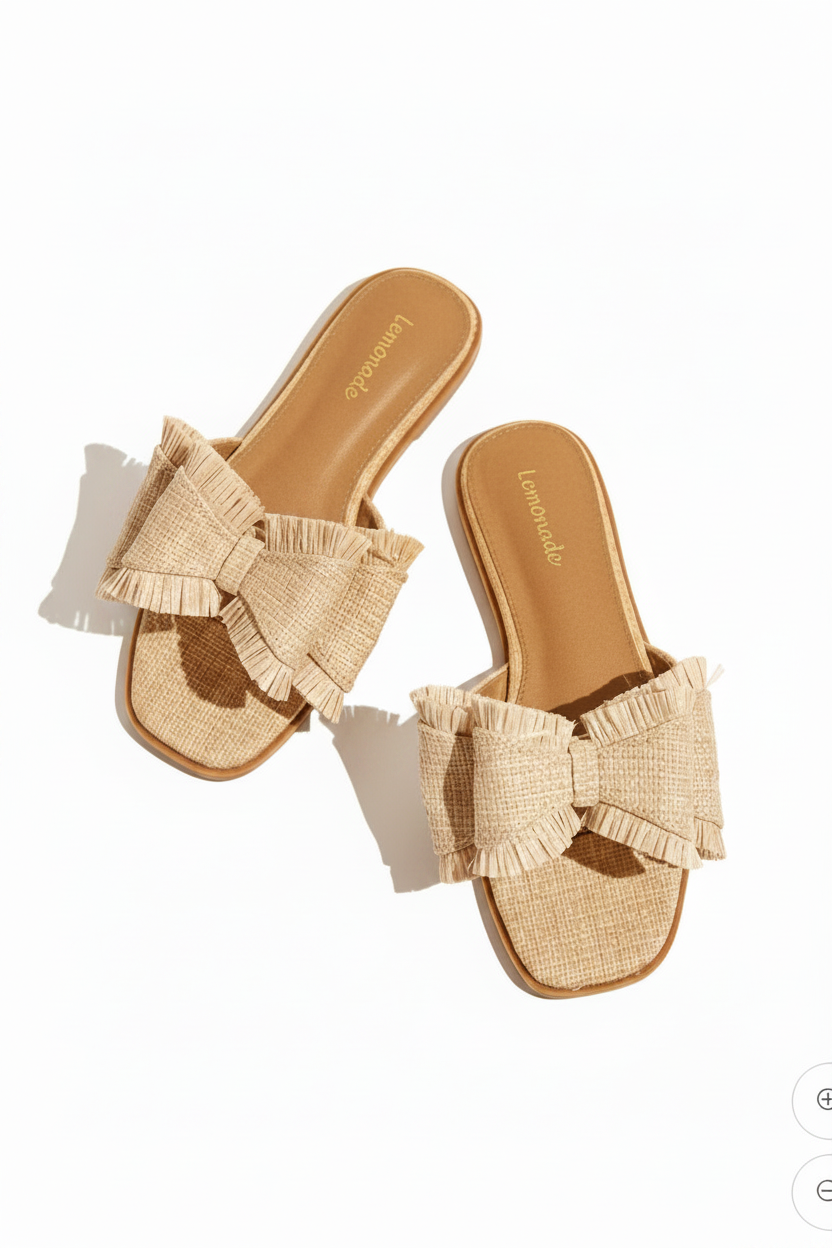 Pair of beige sandals with ruffle details on a beige background
