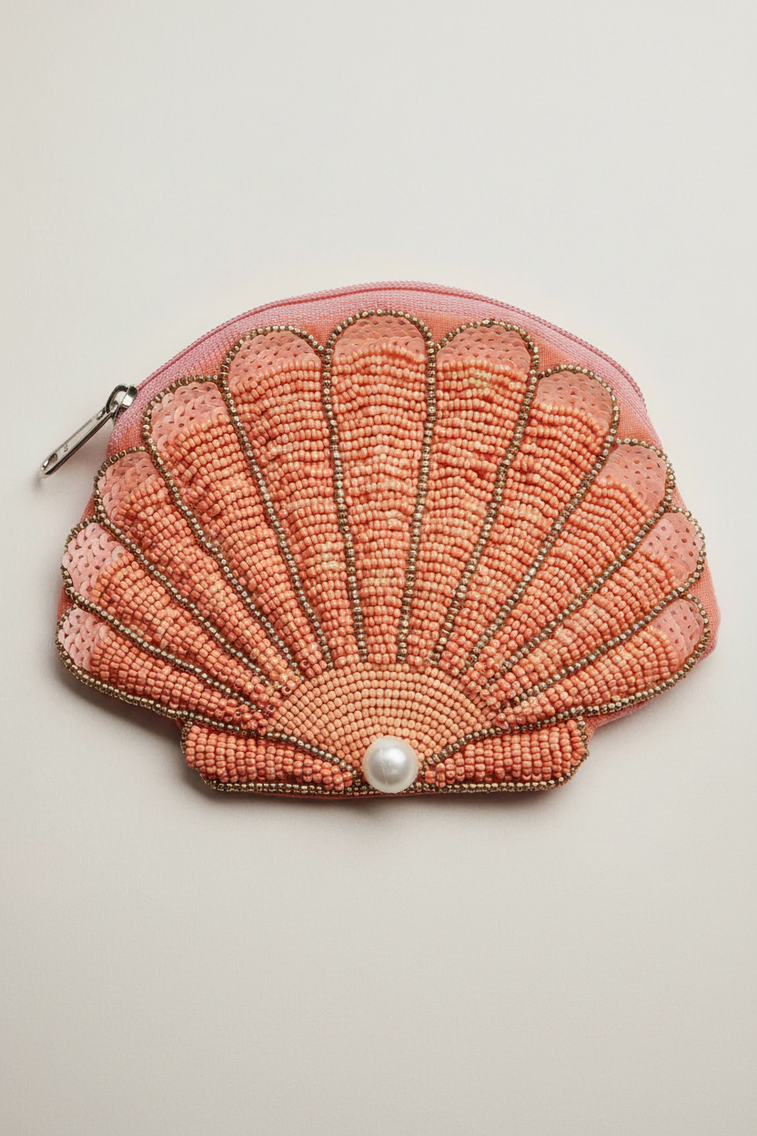 Shell-shaped beaded purse with a pearl on a light background