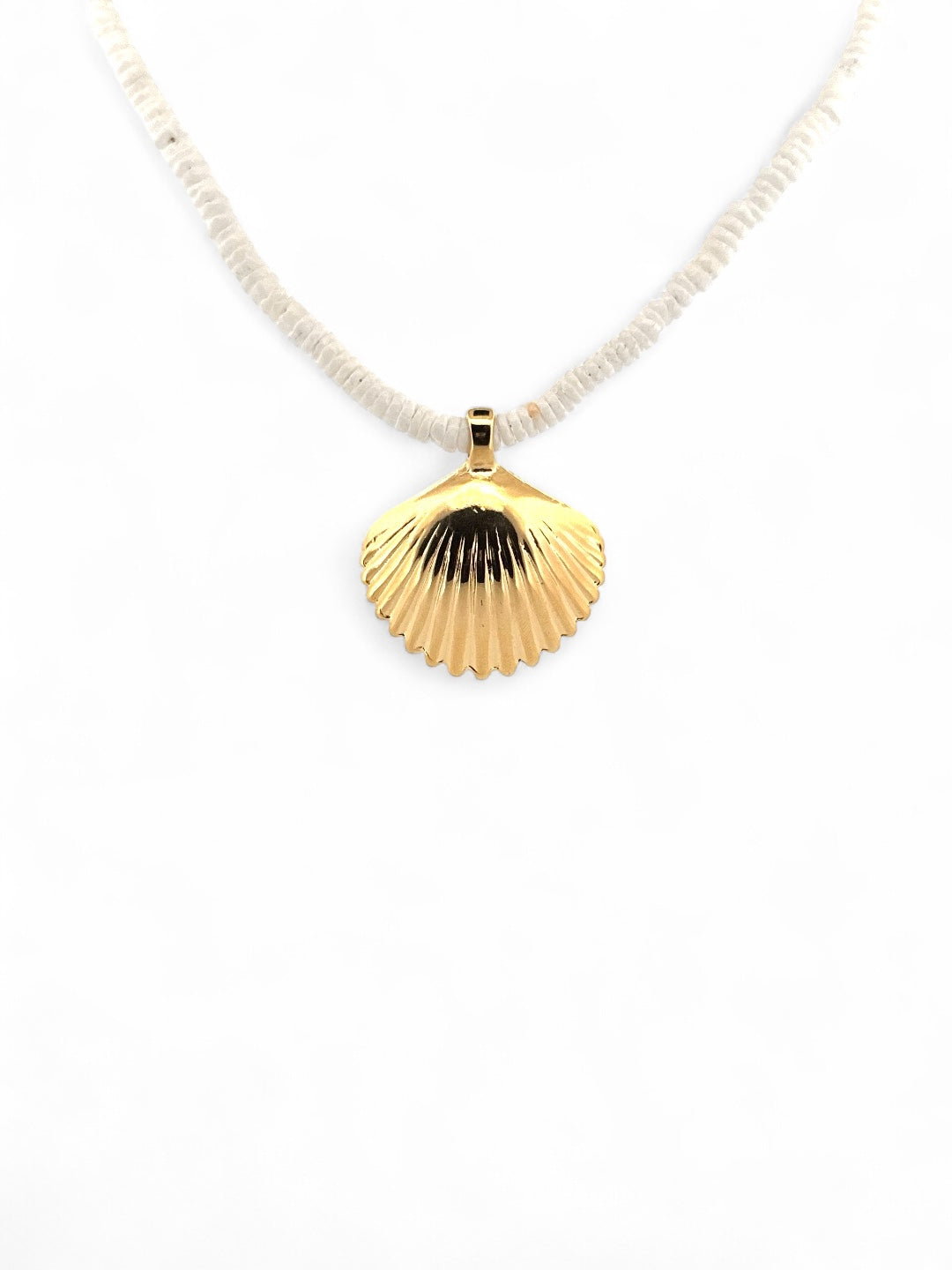 Gold scallop shell necklace with matte white beads styled in natural beach grass from Carolina Benoit