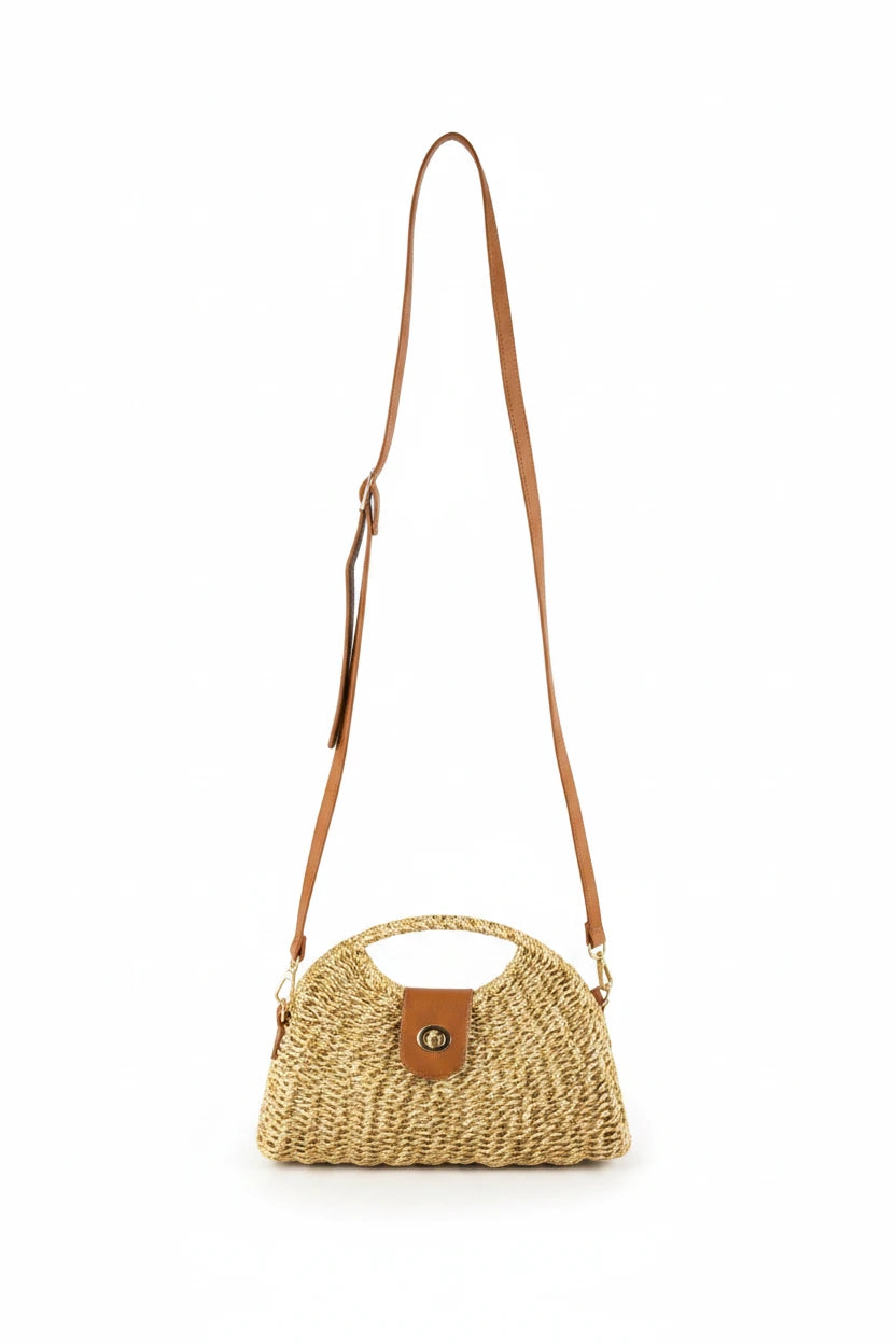 Woven handbag with a brown strap on a wooden surface