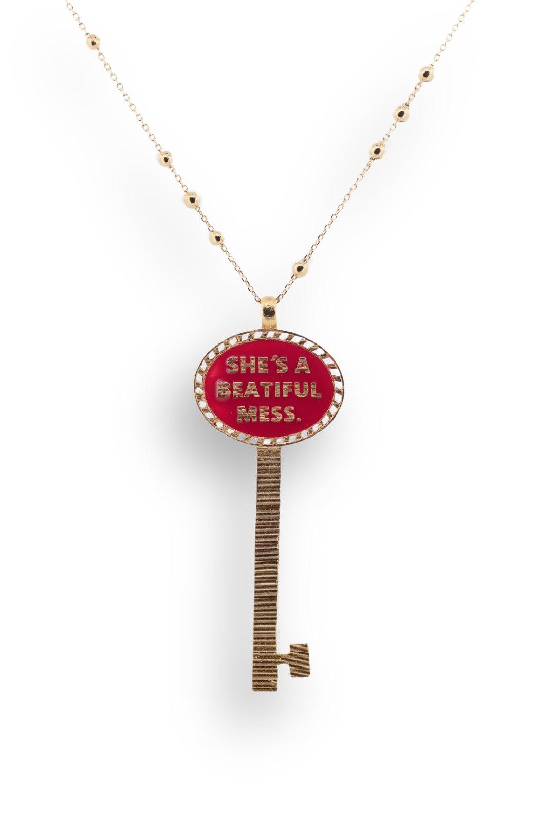 Gold-plated key necklace with bold red enamel reading “She’s a Beautiful Mess.” A statement piece celebrating imperfect beauty and individuality.