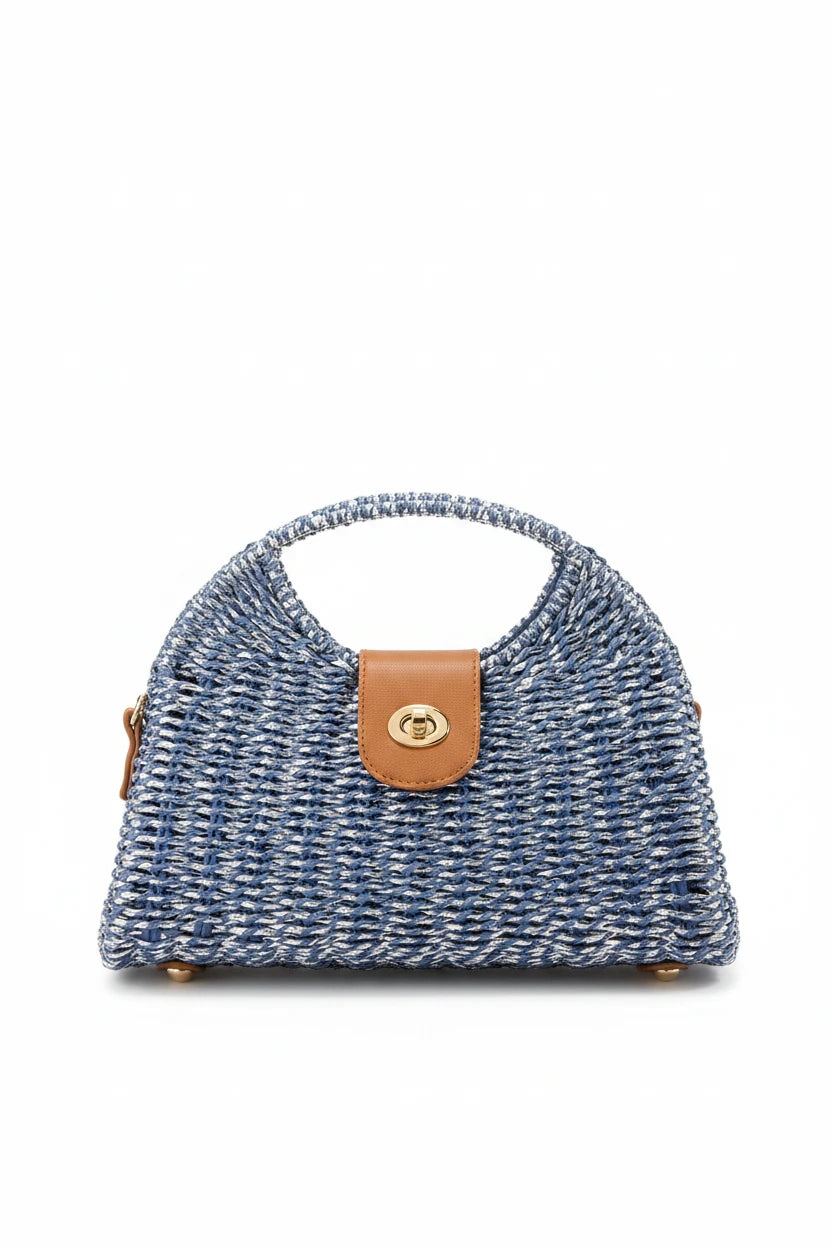 Blue woven handbag with a brown leather patch on a wooden surface