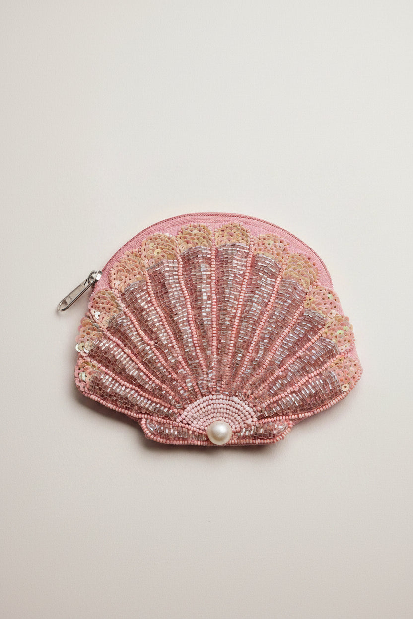 Pink shell-shaped beaded purse with a pearl on a light background