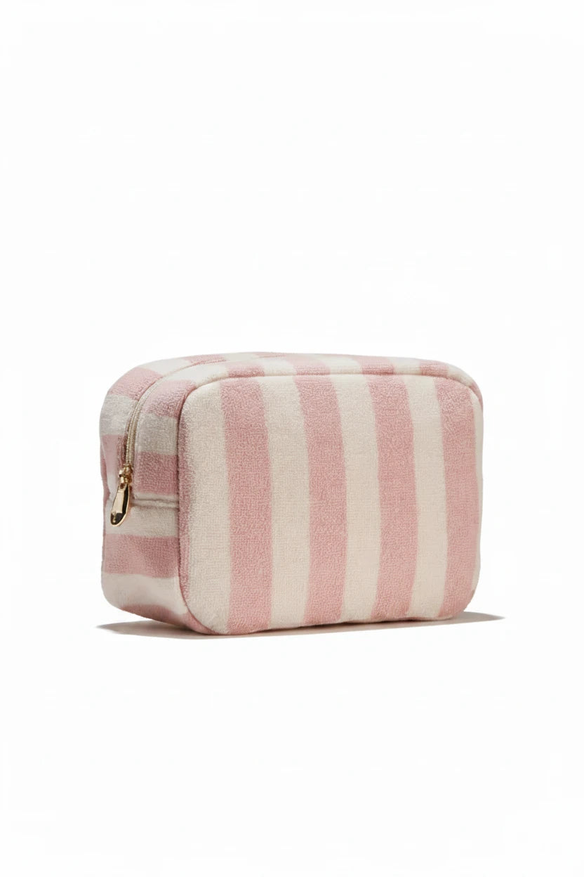 Pink and white striped toiletry bag on a light beige background