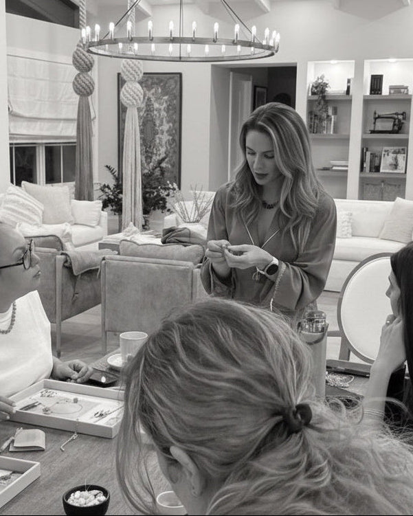 Group of people in a modern living room with a table and chairs.