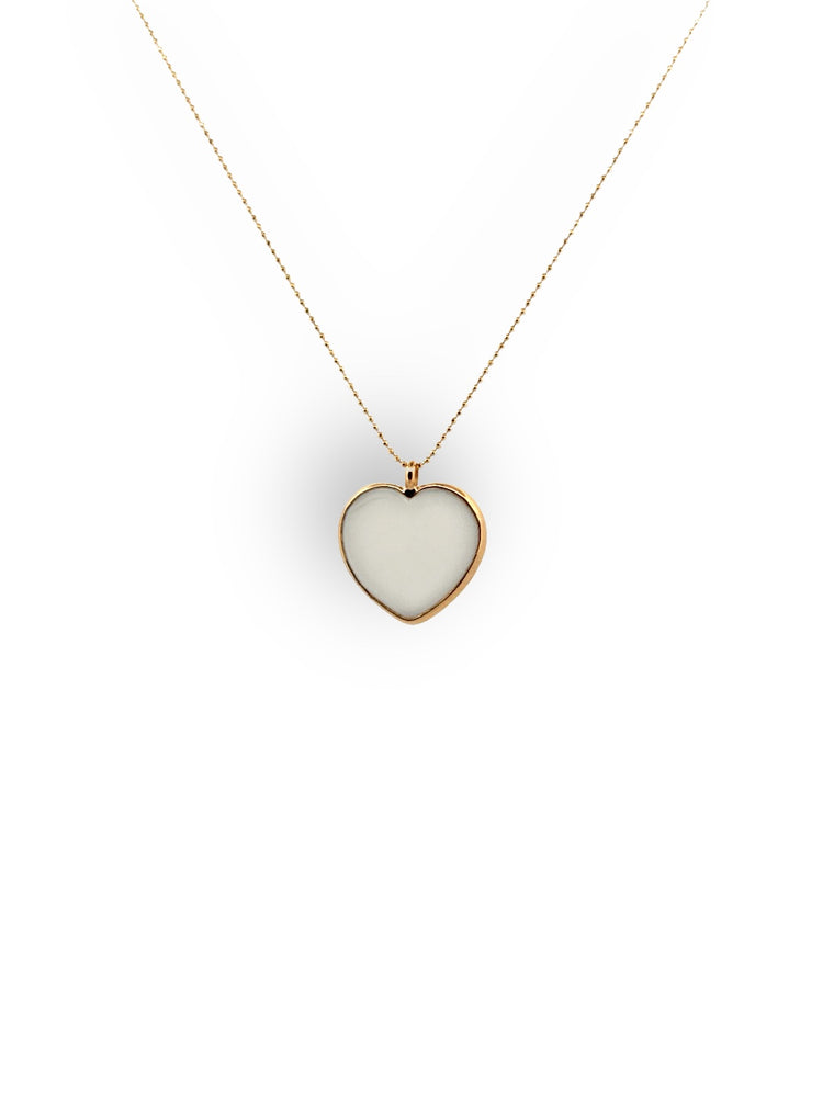 A white glass heart necklace with a gold-plated bezel and chain.