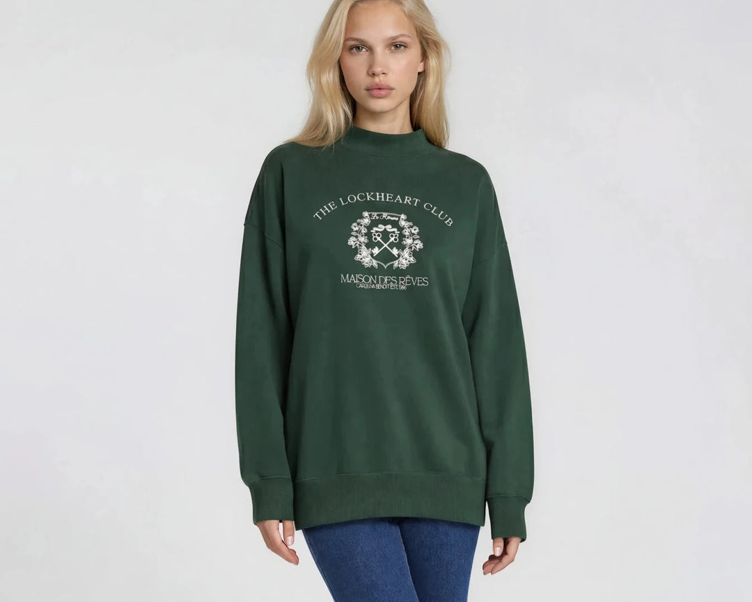 Woman wearing a green sweatshirt with a logo on a white background