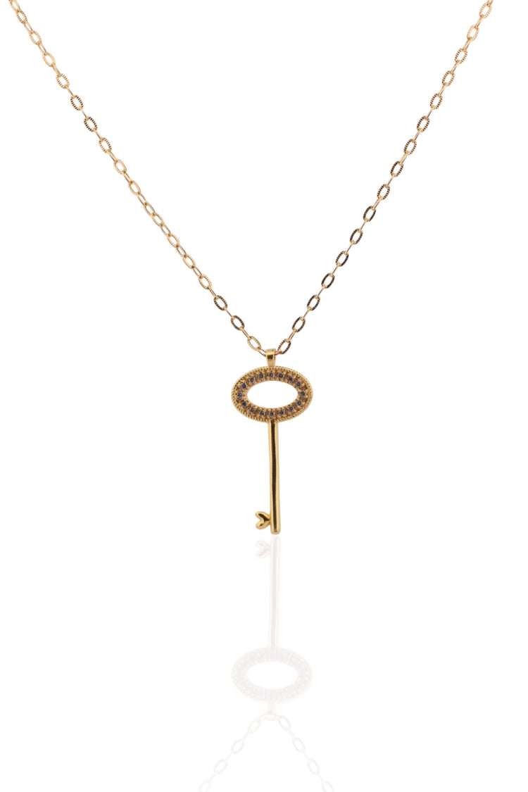 Gold key-shaped key  pendant necklace on a white background