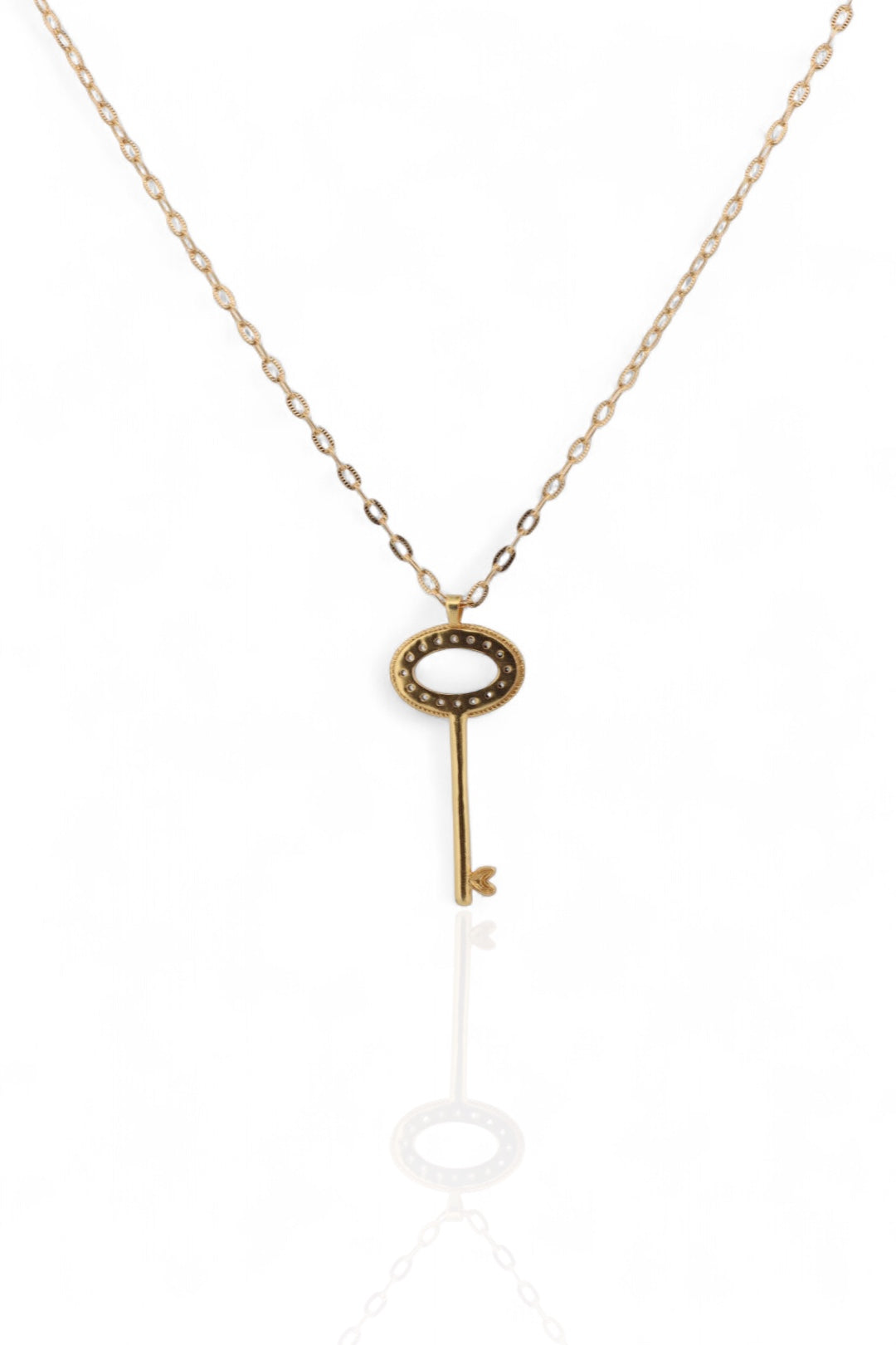 Gold key-shaped key back pendant necklace on a white background