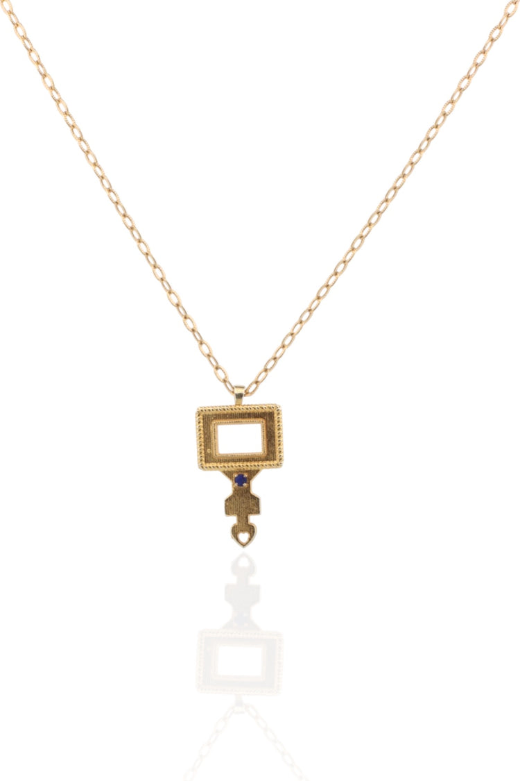 Gold necklace with a rectangular pendant on a white background