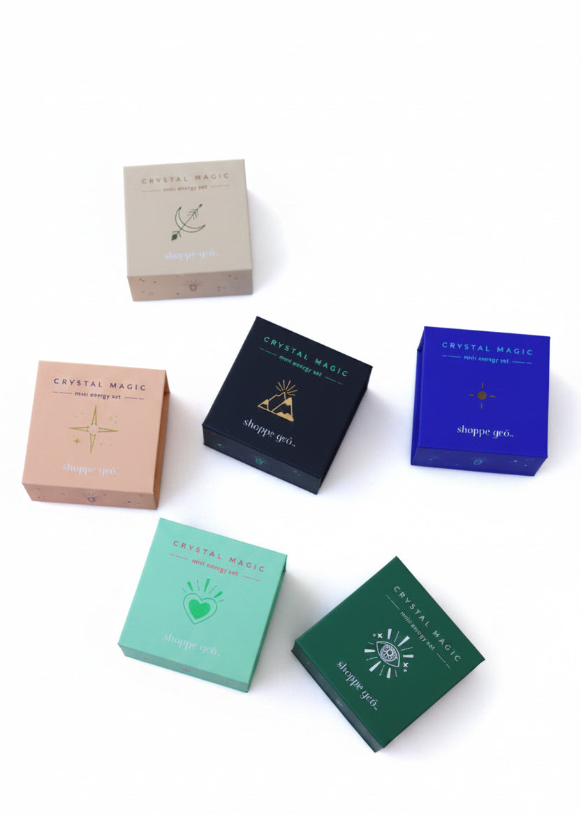 Collection of small boxes with 'Crystal Magic' branding on a marble surface.